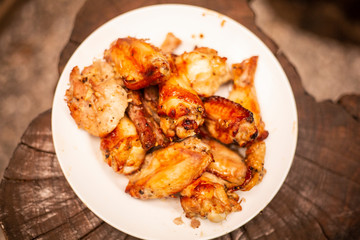 Spicy chicken wings and legs grilling with hot flames.