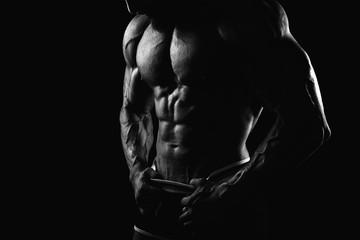 Fototapeta na wymiar Muscular man's torso on black background with backlight Black and White photo
