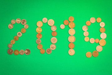 2019 is laid out of various coins on a green background. New year's eve concept