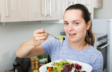cheerful woman eating salad