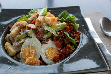 caesar salad mit ei, avocado, croutons, speck und käse