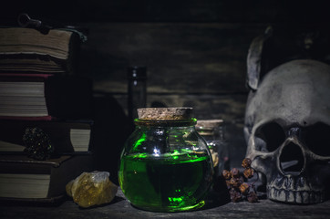 Magic potion and human skull on magic table background. Witchcraft concept.