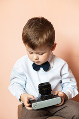 Little boy with aged retro camera. Child with an old camera