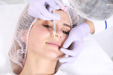 Woman undergoing face biorevitalization procedure in salon, closeup. Cosmetic treatment