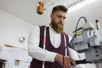Young bearded tailor working on new cloting design