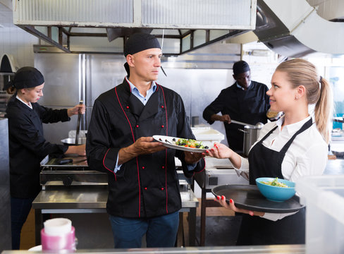 Staff of restaurant with chef working