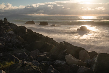dramatic moody atmosphere on atlantic coastline in evening summertime in golden sunset, biarritz, france