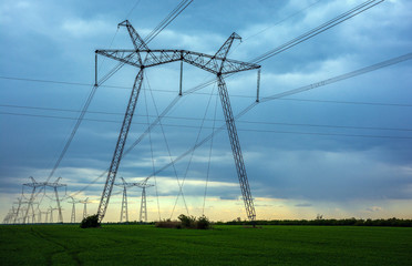  high-voltage power lines at sunset. greeb field.