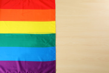 Rainbow gay flag on wooden background, top view with space for text. LGBT concept