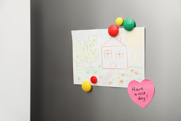 Kid's drawing and magnets on refrigerator door