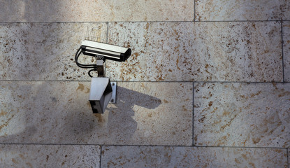 Surveillance CCTV Security Camera on stone wall building facade