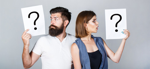 Portrait of couple holding paper question mark. Couple thinking about something. Confused couples...