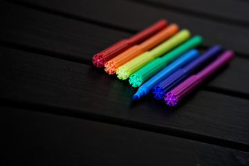 Multi-colored markers laid out in order of the colors of the rainbow