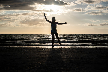 kid jumping silhouette sunset beach