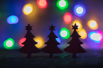 Fototapeta na wymiar Christmas blurred silhouette firtrees with garland lights background, selective focus