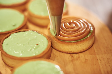 Process of making tart with salted caramel french dessert. Food industry, mass or volume production.