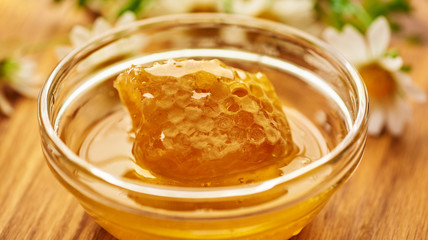 Honeycomb in glass bowl. Close-up of honey. Healthy organic. Sweet dessert background