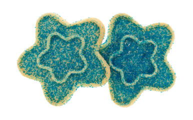 Top view of two star shaped sugar cookies with blue sprinkles isolated on a white background.