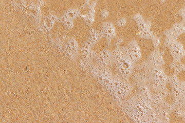 Strand in der Draufsicht mit Blasen im Wasser