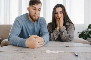 Worried couple with positive pregnancy test. Fertility, pregnancy control and contraception