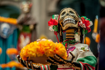 catrina mexicana con moños tricolores y trenzas en una ofrenda y altar del dia de muertos mexicanas calaveras halloween