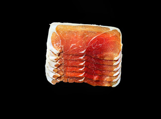 Sliced jamon on black background