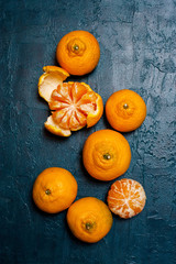 Fresh ripe mandarins on the textured navy blue table