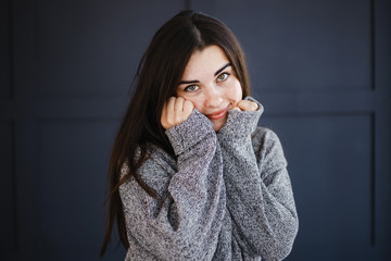 Emotions, feelings and face expression. Cute young confused joyful jolly woman holding head in hands. Portrait on dark background.