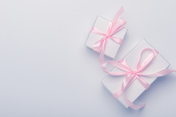 Gift boxes with pink ribbon on white-blue background. Concept holiday gift, congratulations. Top view, copy space, flat lay.