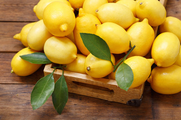 fresh lemons in a wooden box, top view - obrazy, fototapety, plakaty