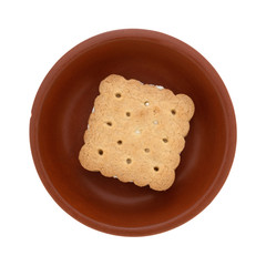 Top view of a single lemon creme cookie in a small dish isolated on a white background.