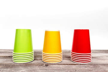 Stacks of empty colorful disposable paper cups of red, yellow and green color