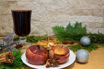 Red mulled wine and baked apples with melting honey, nuts and spices, cinnamon and anise. Decorated...