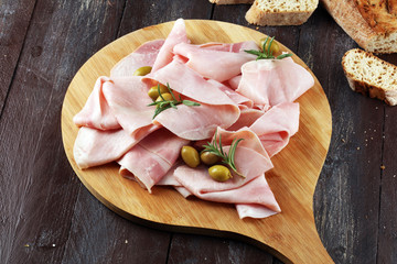 Sliced ham on wooden background. Fresh prosciutto. Pork ham sliced.