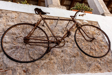 old rusty bicycle hanging on a white wall