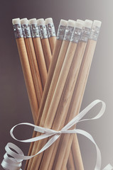 Set of pencils decorated with a white gift ribbon. 