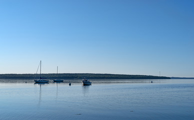 Fototapeta na wymiar Early morning wide view of boats moored on Penobscot Bay at Searsport, Maine with Sears Island in the background.
