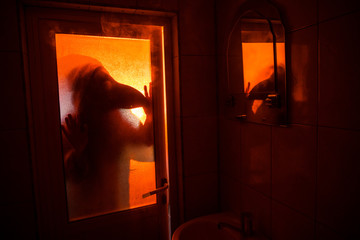 Horror silhouette of woman in window. Scary halloween concept Blurred silhouette of witch in bathroom. Selective focus