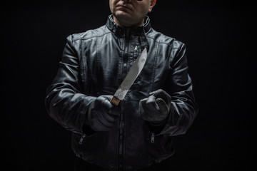 Serial killer maniac with knife and black gloves