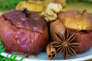 Baked apples with cinnamon and anise stars, stuffed with nuts and raisins, healthy food. Tasty christmas dessert. Close up. Macro.