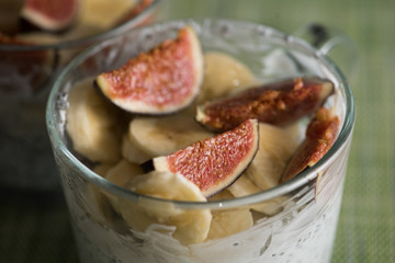 Pieces of figs and banana in yogurt with chia seeds in glass cups