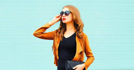 Fashion portrait young woman in sunglasses on wall background