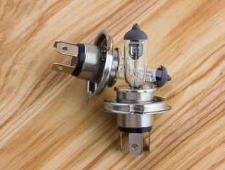 Electric lamps from a car on a wooden surface. Two head lamps for a car close-up on a wooden surface.