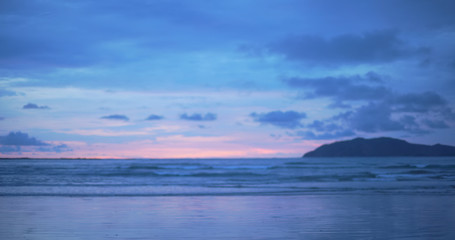 Fototapeta premium Out of focus background plate of beautiful purple and blue sunset on the beach