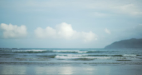 Obraz premium Blurred shot of beautiful clouds and low tide waves on tropical beach