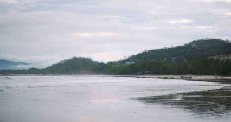 Obraz premium Background of typical Costa Rica beach with calm sea waves and tree landscape