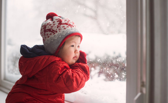 Baby looking at snow from window