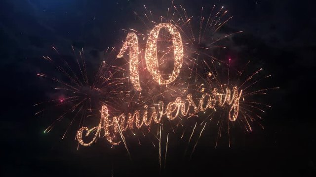 Happy birthday Anniversary 10 years celebration greeting text with particles and sparks on black night sky with colored slow motion fireworks on background, beautiful typography magic design.