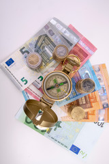 golden compass with banknotes and coins