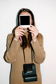 Young woman with polaroid camera and shot